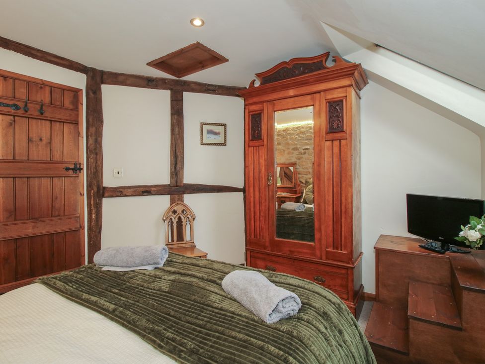 A bedroom with a bed and a wardrobe at Corn House in Cardington