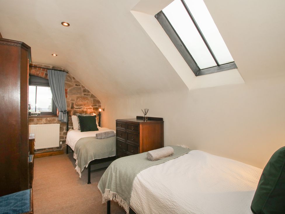 A bedroom with two beds and a dresser at Corn House in Cardington