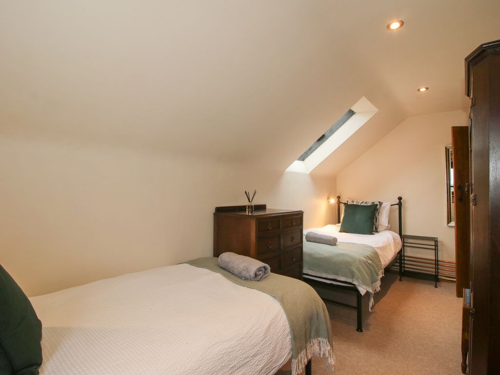 A bedroom with two beds and a dresser at Corn House in Cardington