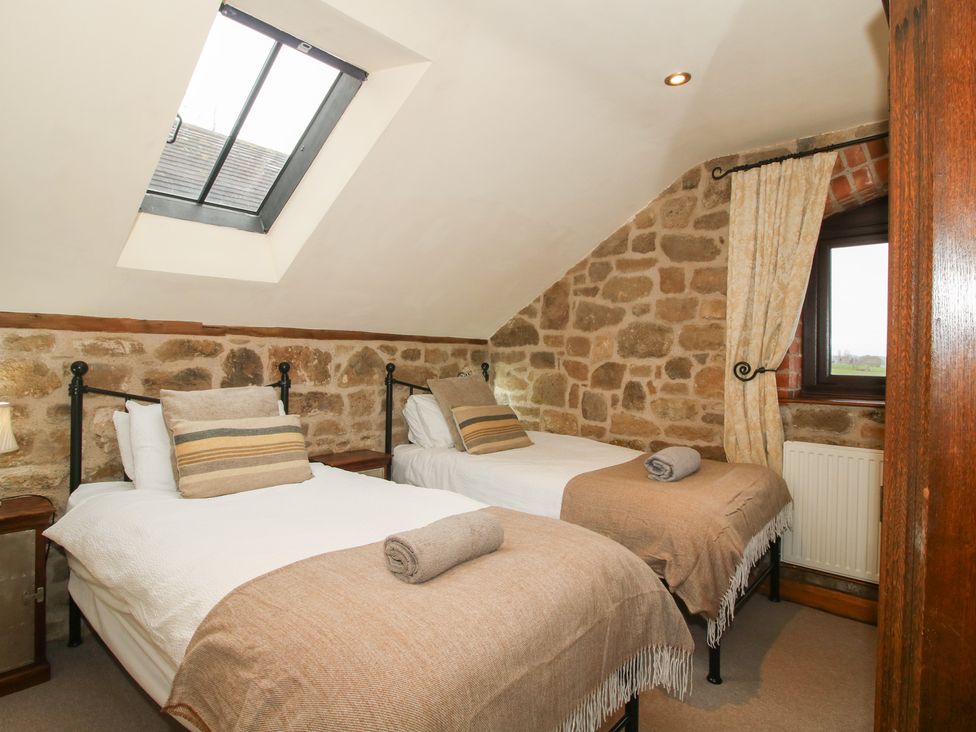 A bedroom with two beds and a window at Corn House in Cardington