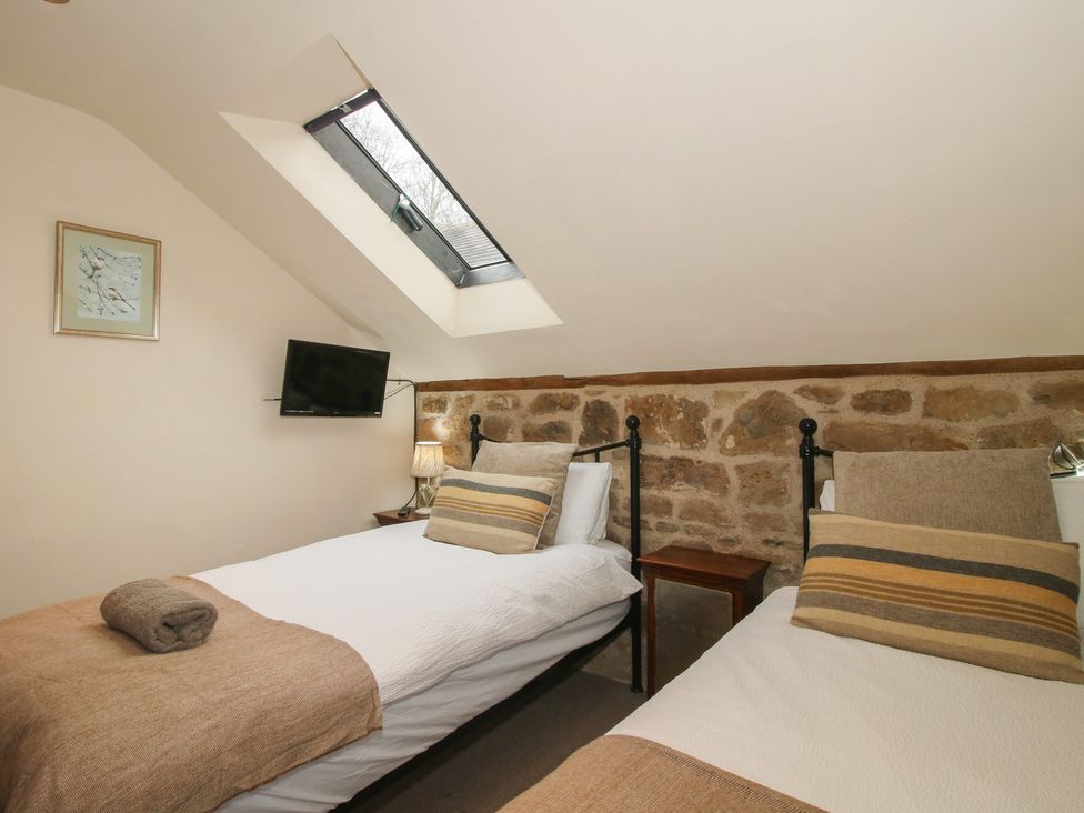 A bedroom with two beds and a TV at Corn House in Cardington