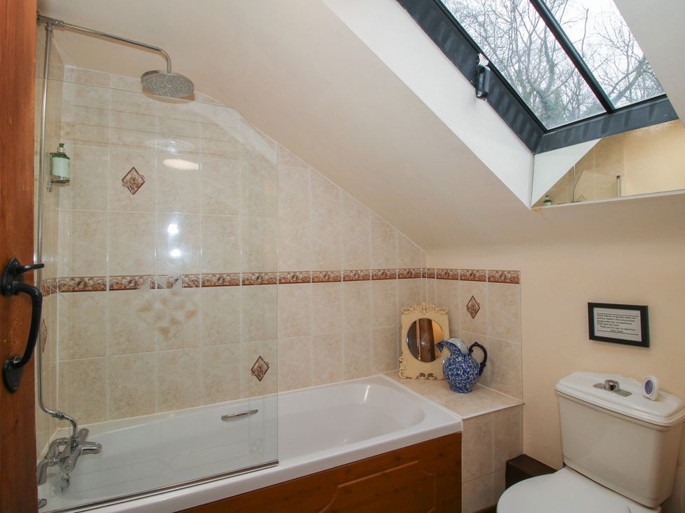 A bathroom with a shower, bathtub, mirror, toilet, and sink at Corn House in Cardington