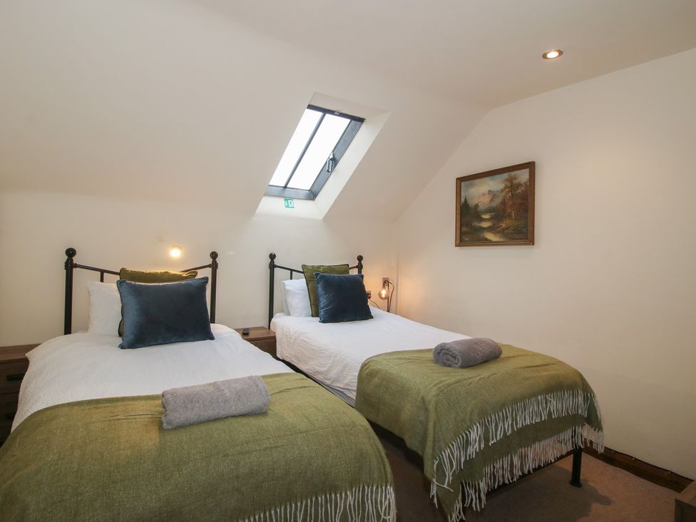 A bedroom with two beds and a painting at Corn House in Cardington