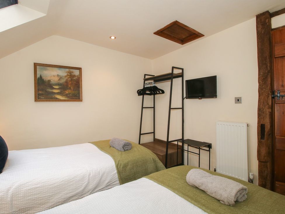 A bedroom with twin beds and a wall-mounted television at Corn House in Cardington