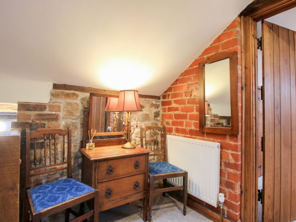 A bedroom with a dressing table and chairs at Corn House in Cardington