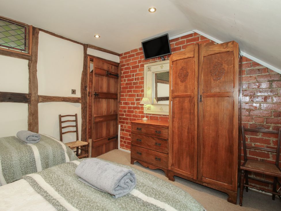 A bedroom with a bed and wooden furniture at Corn House in Cardington