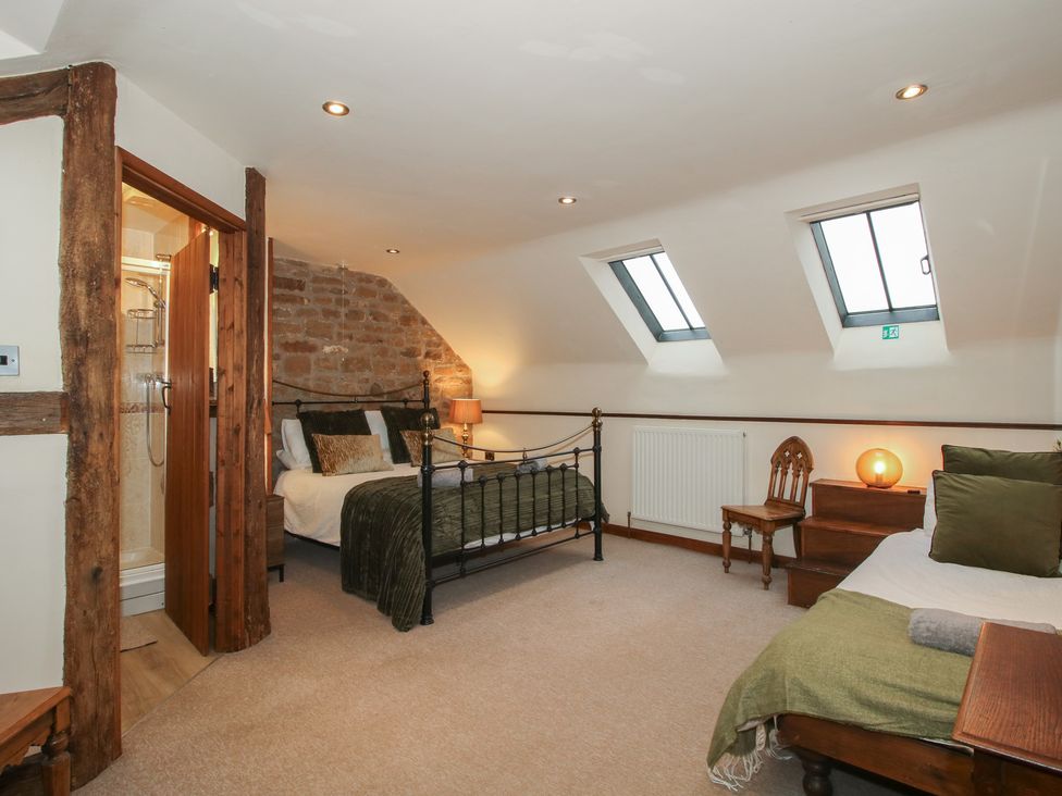 A bedroom with a bed, shower and window at Corn House in Cardington