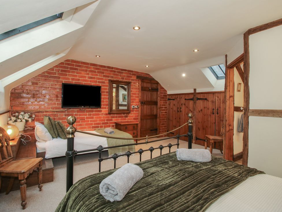 A bedroom with a bed and wardrobe at Corn House in Cardington
