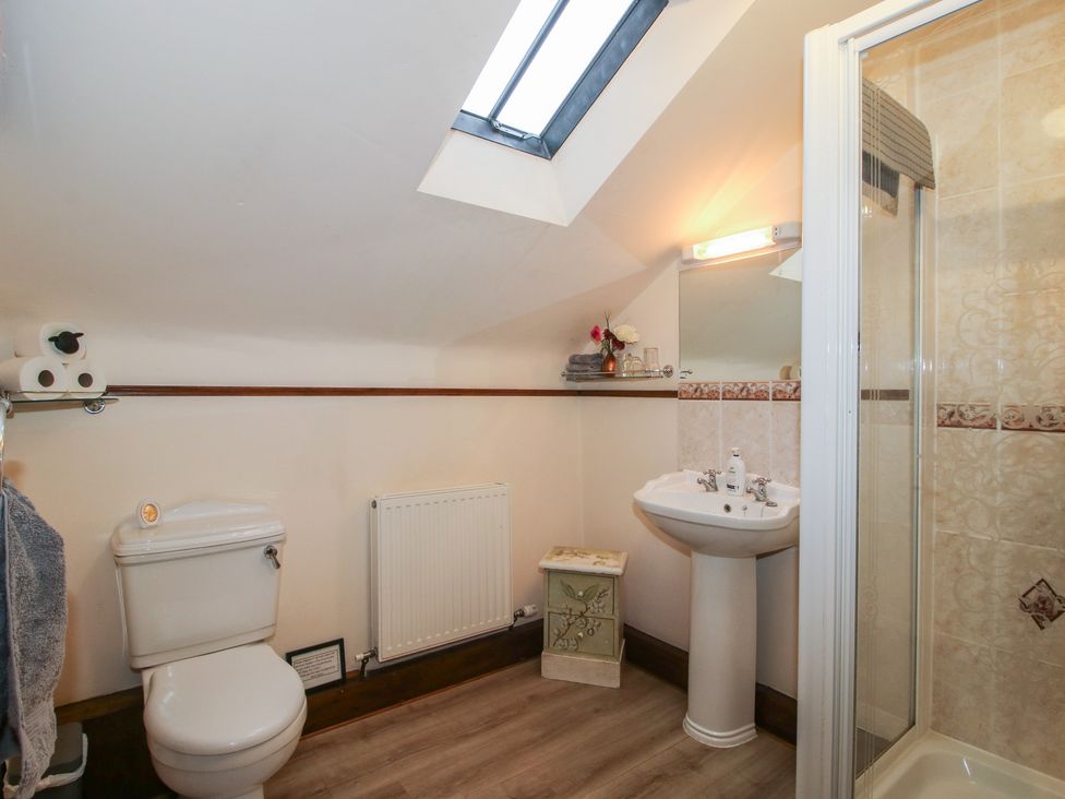 A bathroom with a toilet, sink, and shower at Corn House in Cardington
