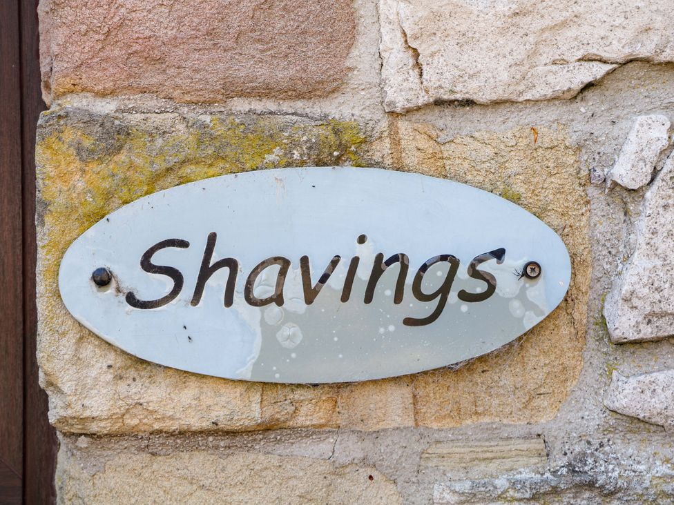 A sign labeled Shavings mounted on a stone wall at The Shavings in Cowdale near Buxton