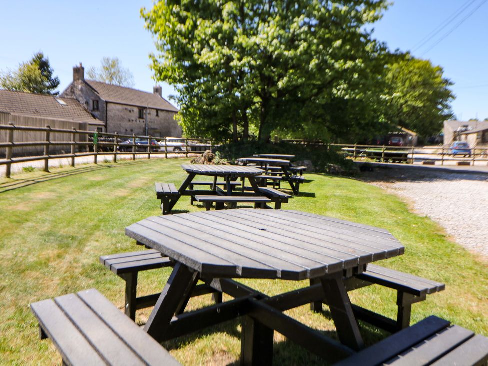 An outdoor area with picnic tables and trees at The Shavings in Cowdale near Buxton
