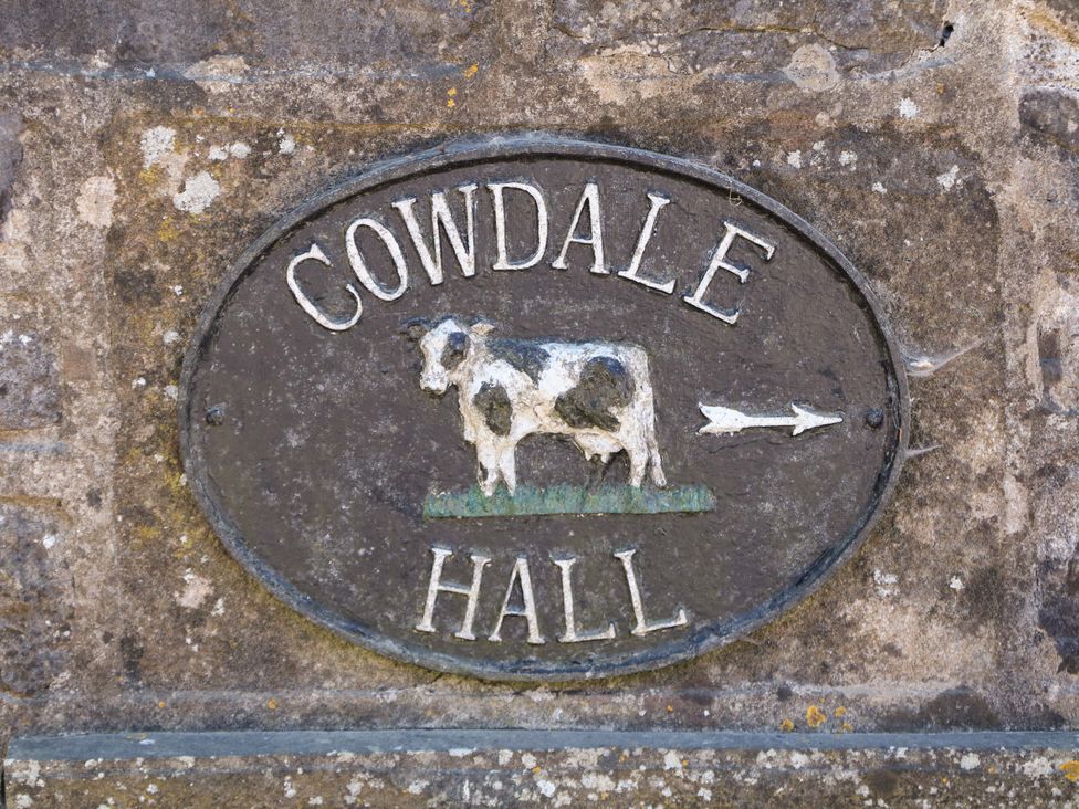 A sign with Cowdale Hall and cow graphic at The Shavings in Cowdale near Buxton