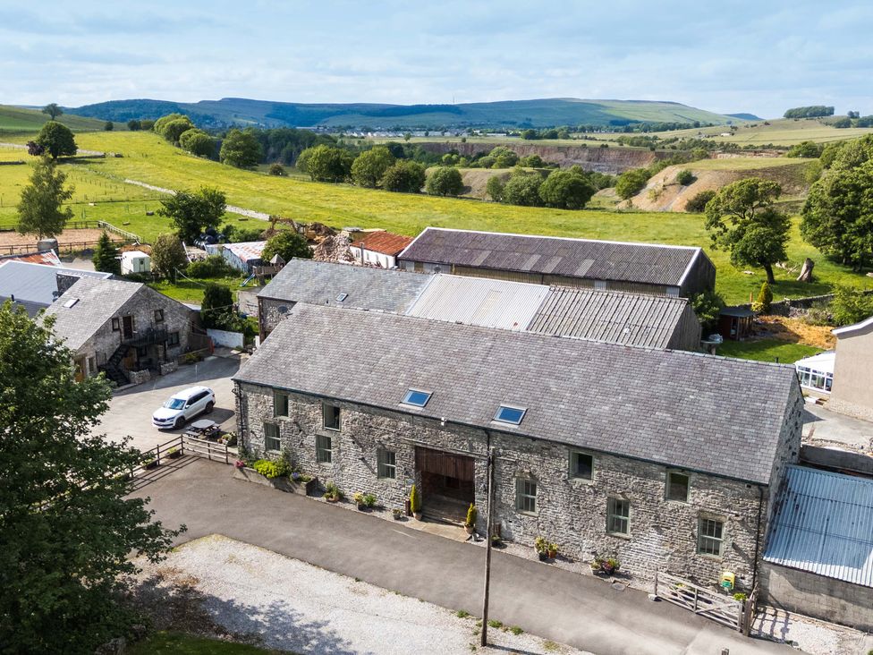An aerial view of a property with buildings and fields at Woodlands in Cowdale near Buxton