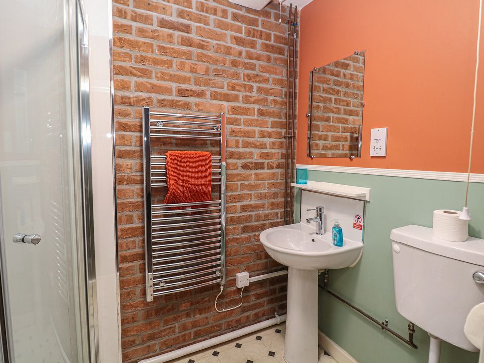 A bathroom with a sink, toilet, and towel rail at Woodlands in Cowdale near Buxton