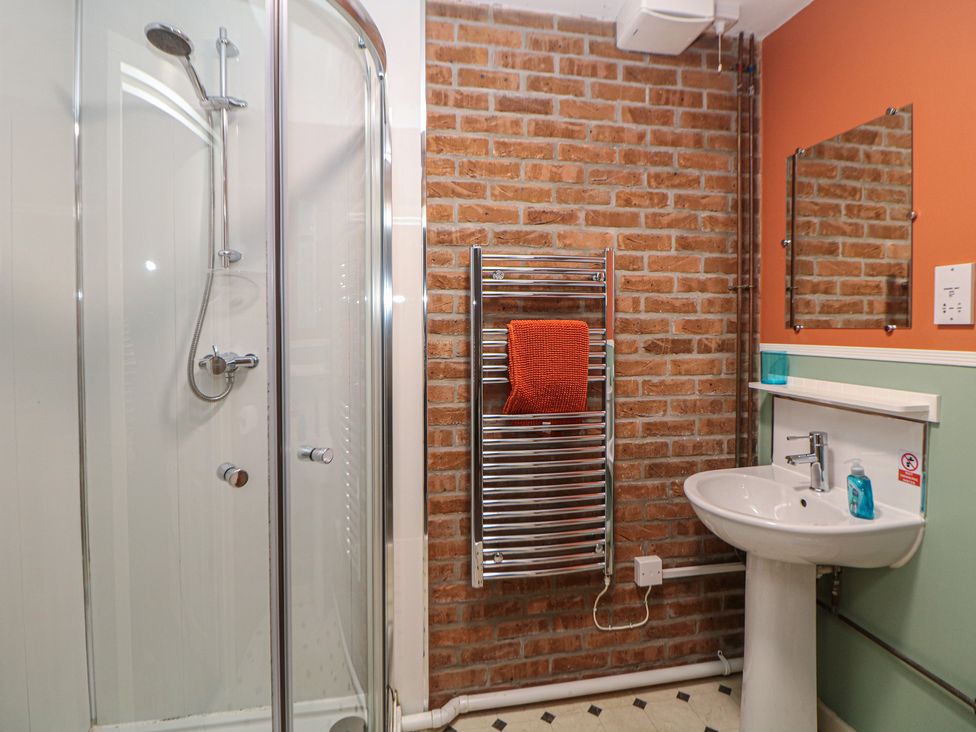 A bathroom with a shower, sink, and towel radiator at Woodlands in Cowdale near Buxton