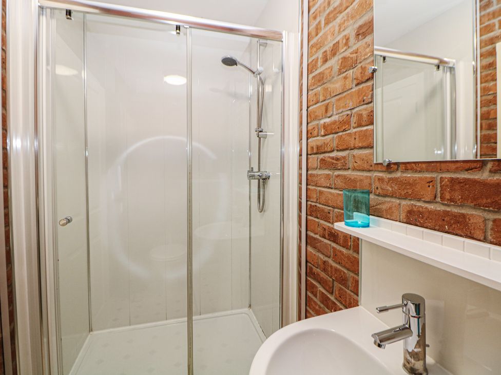 A bathroom with a shower and sink at Woodlands in Cowdale near Buxton