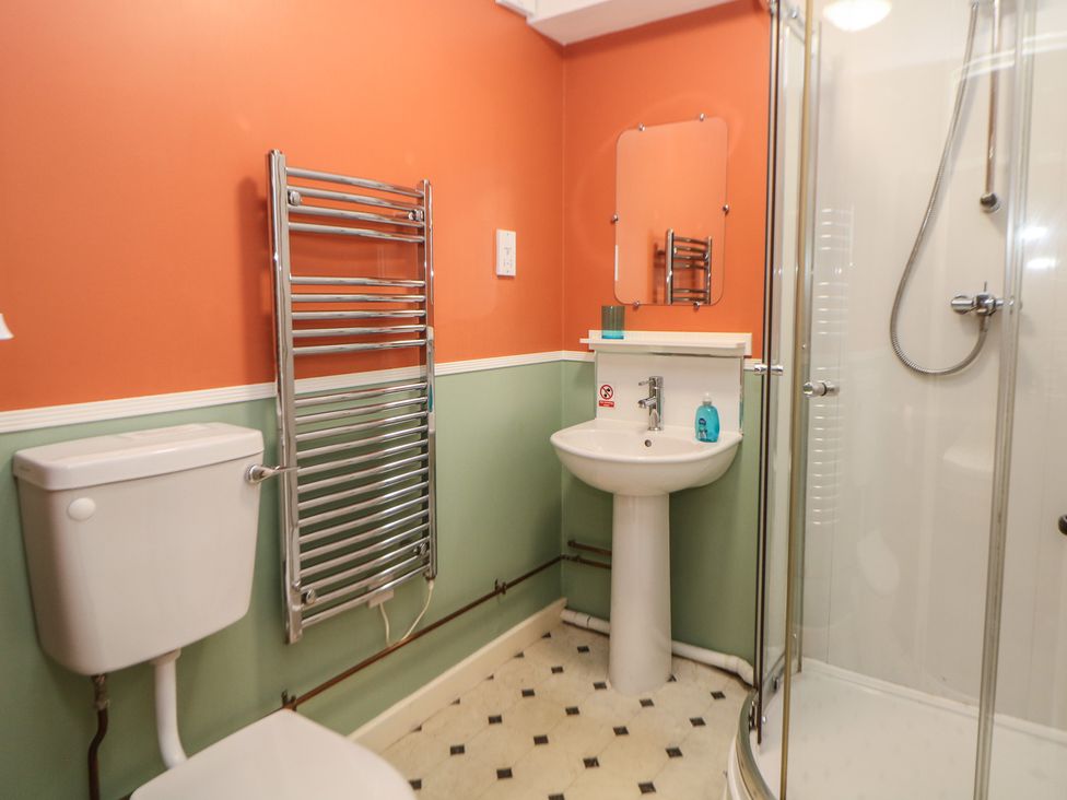 A bathroom with a shower, sink, toilet, and towel radiator at Meadow View in Buxton