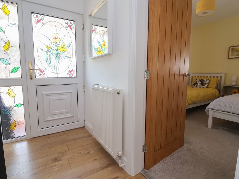 A hallway with a stained glass door and access to a bedroom at Hillcrest in Cefn Mawr near Chirk