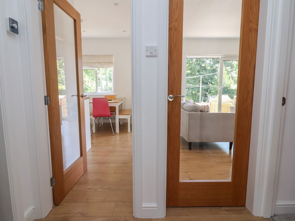 A hallway with doors leading to a dining area and living room at Hillcrest in Cefn Mawr near Chirk