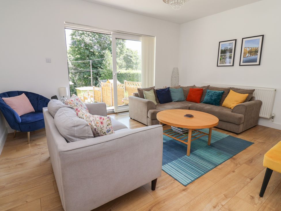 A living room with a sofa and armchair at Hillcrest in Cefn Mawr near Chirk
