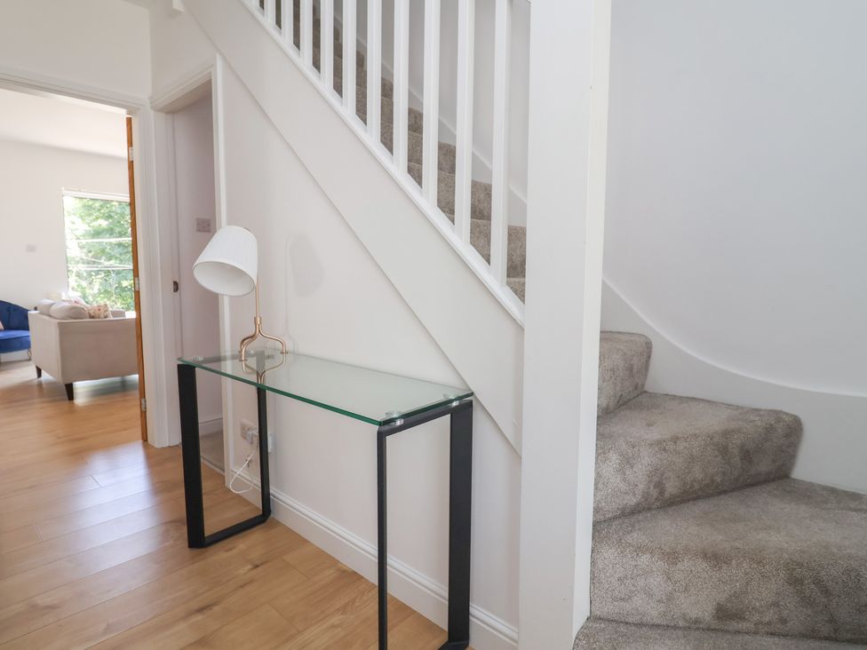 A hallway with stairs and a console table at Hillcrest in Cefn Mawr near Chirk