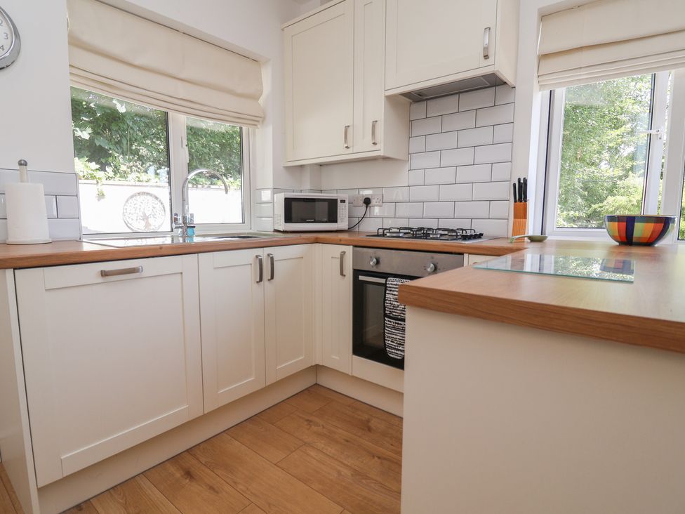 A kitchen with a sink, microwave and gas stove at Hillcrest in Cefn Mawr near Chirk
