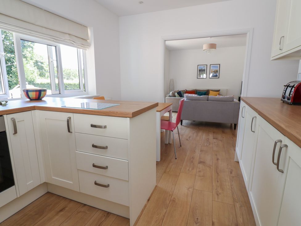 A kitchen with cabinets and a dining area at Hillcrest in Cefn Mawr near Chirk