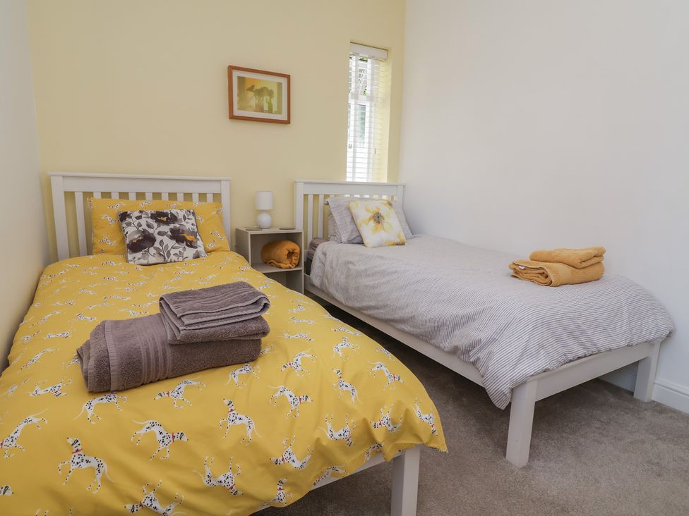 A bedroom with two beds and a bedside table at Hillcrest in Cefn Mawr near Chirk