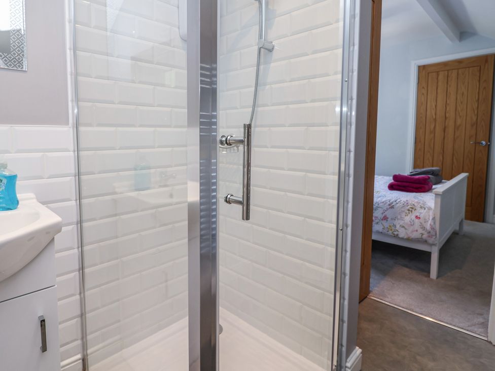 A bathroom with a shower and sink at Hillcrest in Cefn Mawr near Chirk