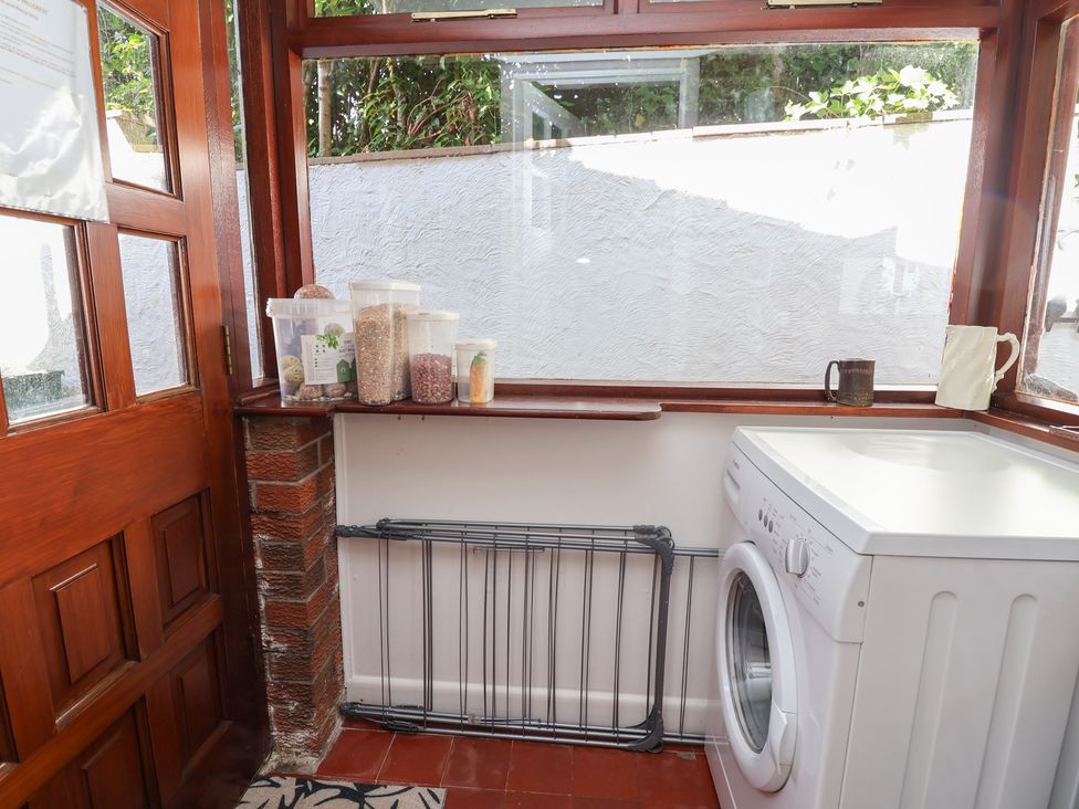 A utility room with a washing machine and storage containers at Hillcrest in Cefn Mawr near Chirk