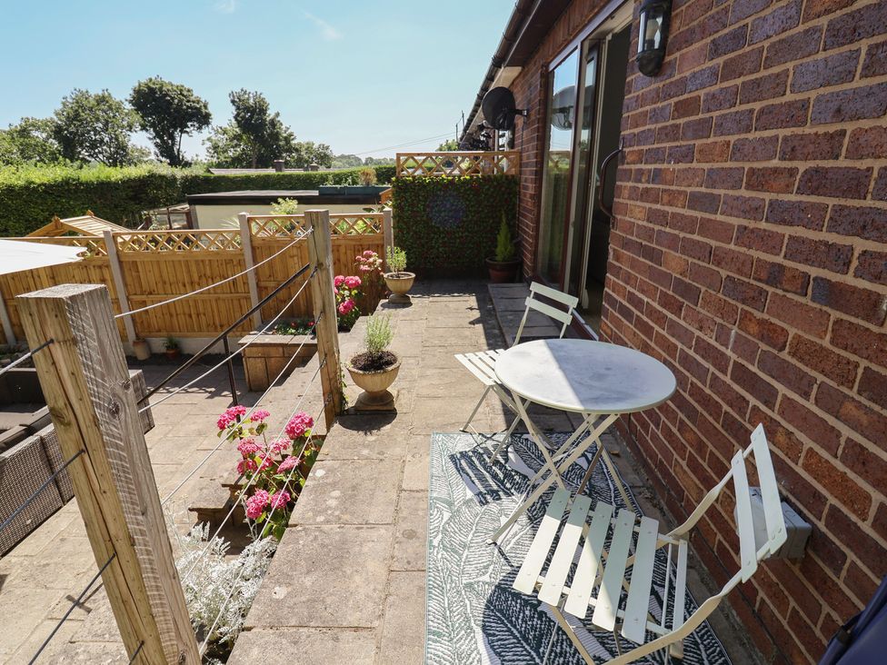 A patio area with a table and chairs at Hillcrest Cefn Mawr near Chirk