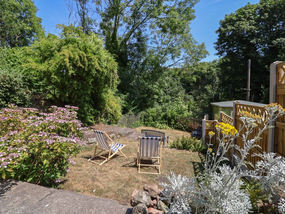 A garden with deck chairs and flowers at Hillcrest in Cefn Mawr near Chirk