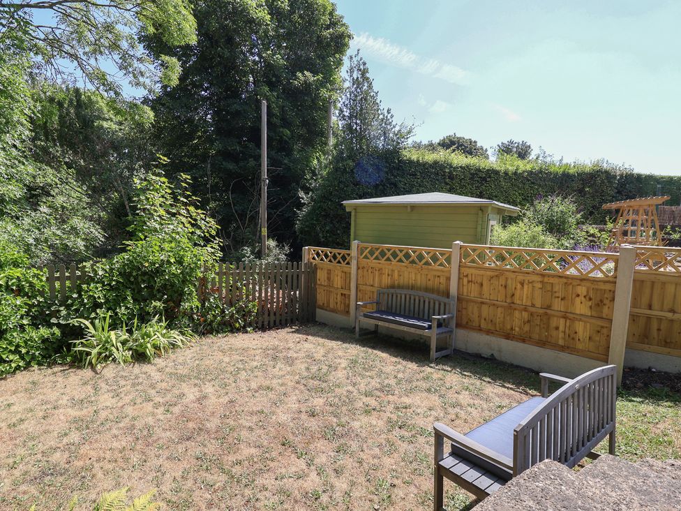 A garden with benches and a shed at Hillcrest in Cefn Mawr near Chirk