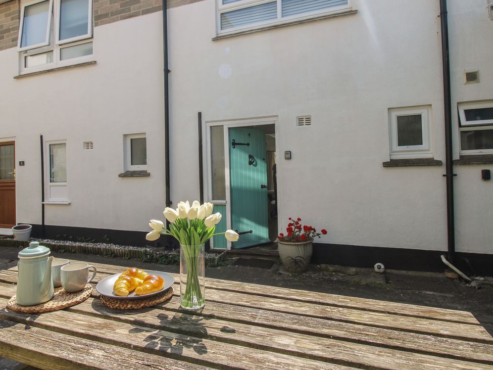 An outdoor table with coffee pot and flowers at 4 Thornlea Mews Hope Cove