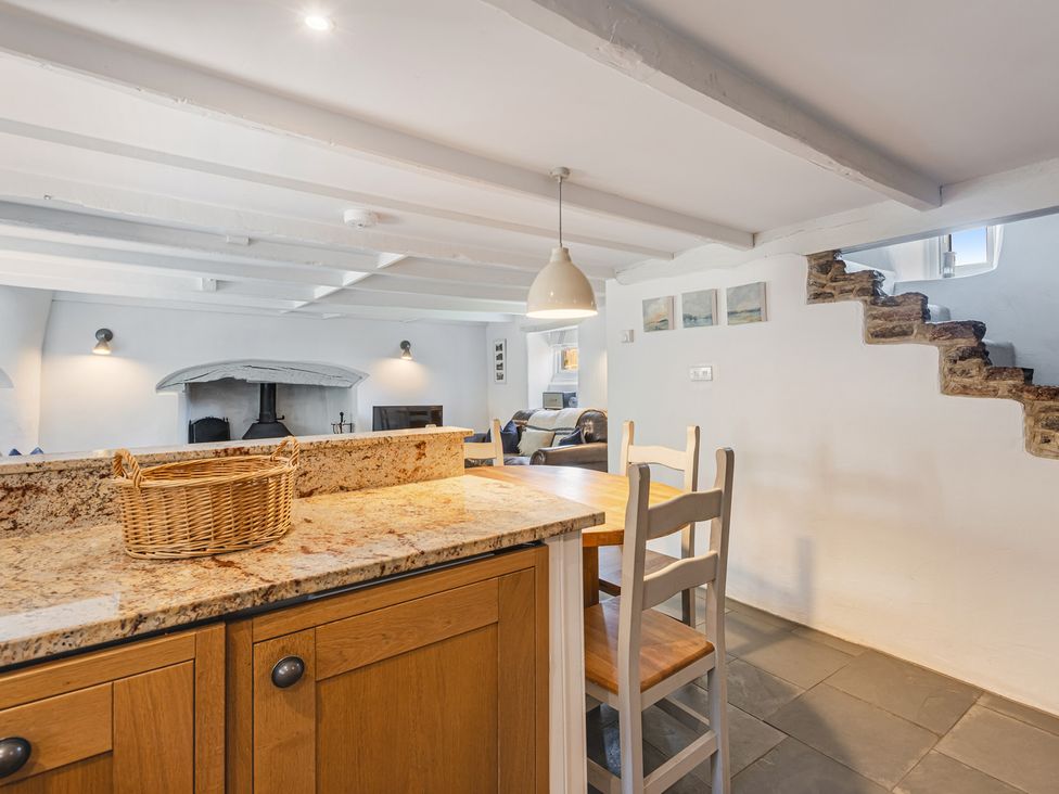 A kitchen with a dining table and staircase at 3 Glendale Cottages Dittisham near Dartmouth