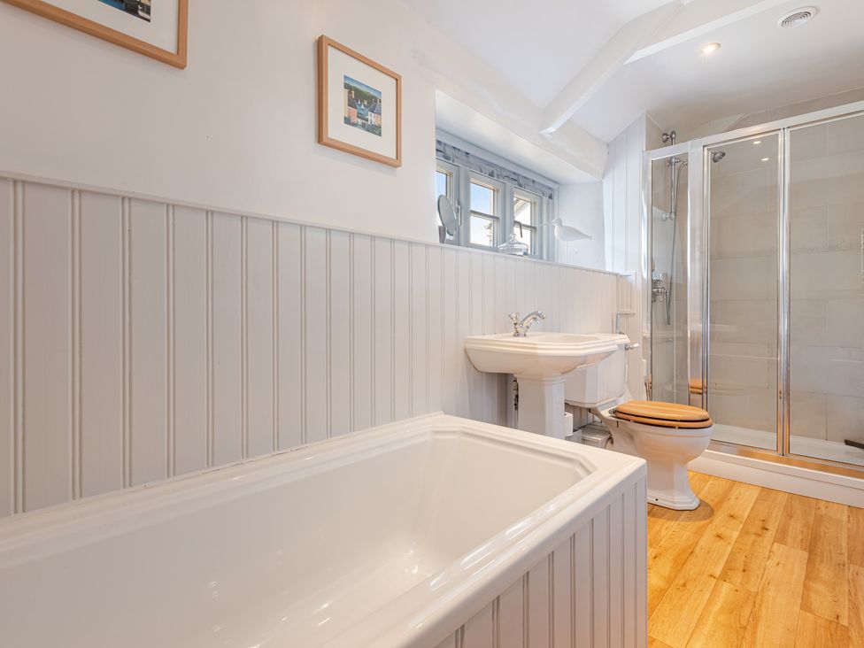 A bathroom with a bathtub, shower, and sink at 3 Glendale Cottages Dittisham near Dartmouth