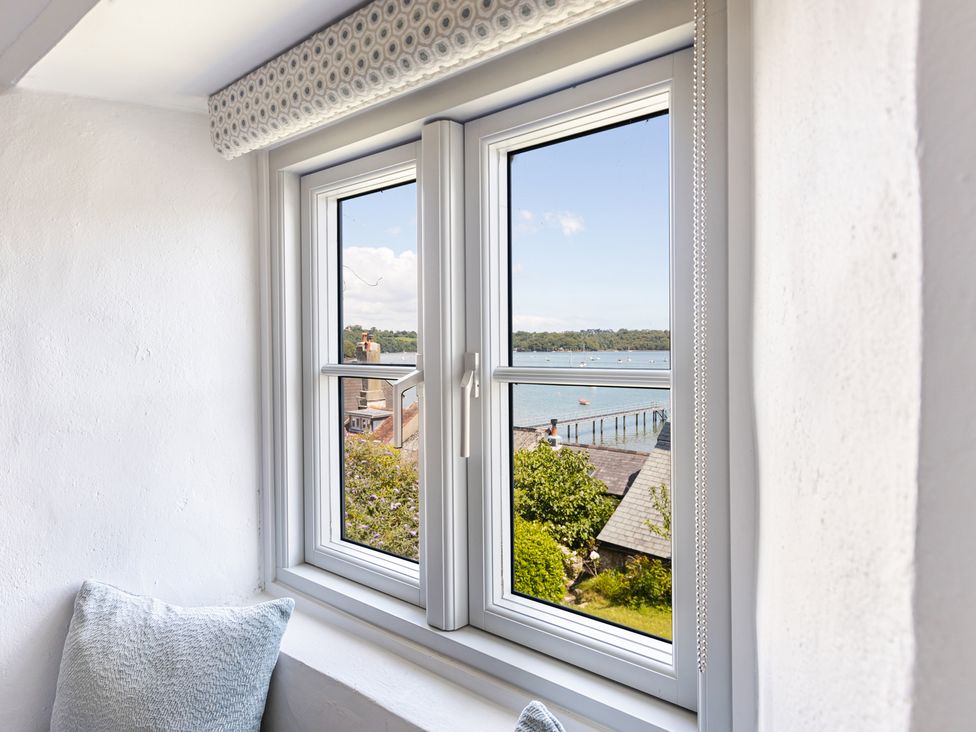A window with a view of the water and buildings at 3 Glendale Cottages Dittisham near Dartmouth