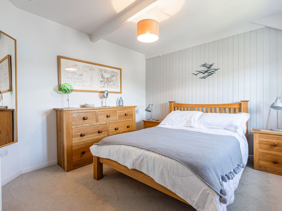 A bedroom with a bed and wooden furniture at 3 Glendale Cottages Dittisham near Dartmouth