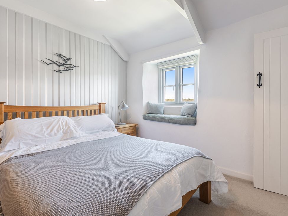 A bedroom with a bed and bedside table at 3 Glendale Cottages in Dittisham near Dartmouth