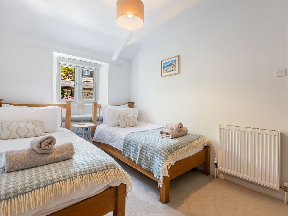 A bedroom with two beds and a window at 3 Glendale Cottages Dittisham near Dartmouth