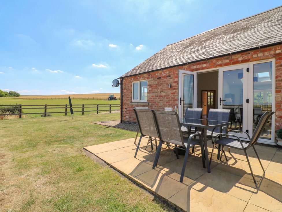 An outdoor seating area with a table and chairs at Teal Cottage in Melton Mowbray