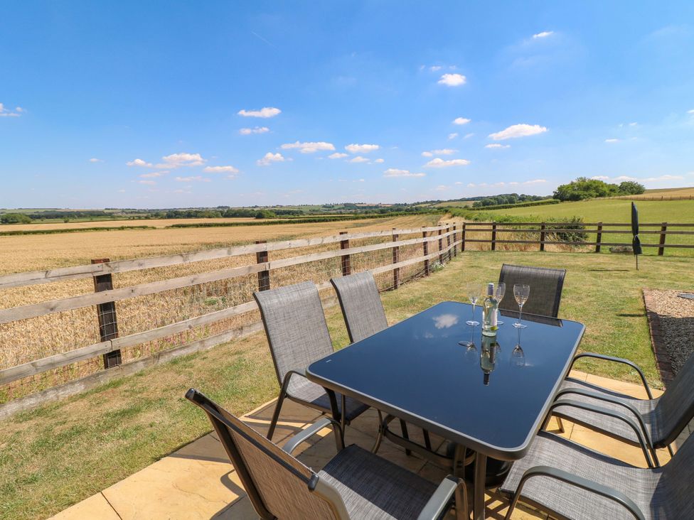 An outdoor seating area with a table and chairs at Teal Cottage in Melton Mowbray