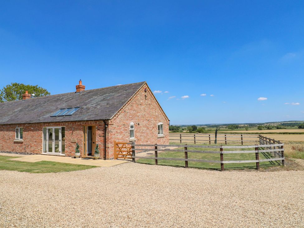 A house with a gate and fence in a rural landscape at Teal Cottage Melton Mowbray