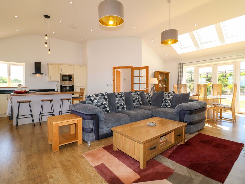 A living room with a sofa and dining table at Teal Cottage Melton Mowbray