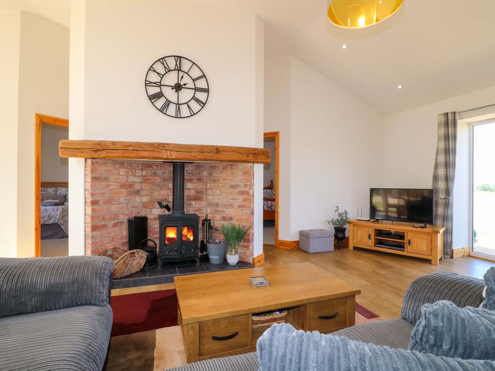 A living room with a wood stove and a television at Teal Cottage Melton Mowbray
