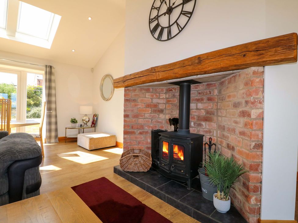 A living room with a fireplace and seating area at Teal Cottage in Melton Mowbray