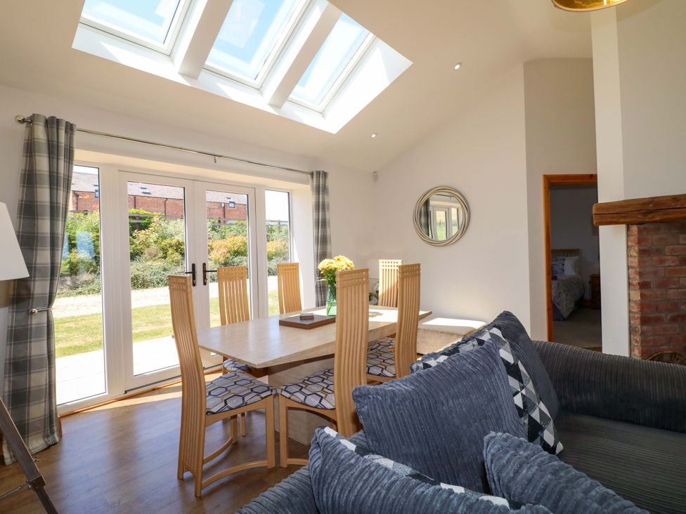 A dining room with a table and chairs at Teal Cottage Melton Mowbray