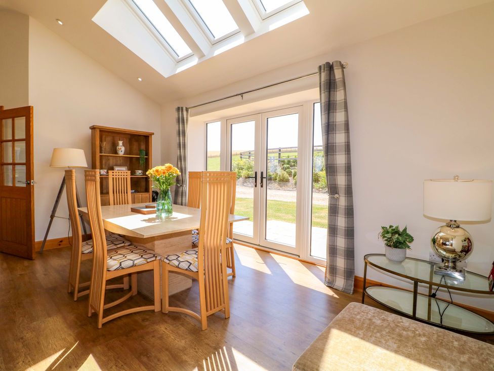 A dining room with a table and chairs at Teal Cottage Melton Mowbray