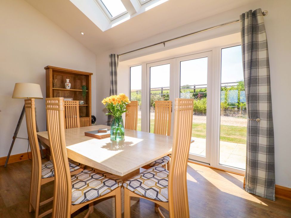 A dining room with a table and chairs at Teal Cottage Melton Mowbray