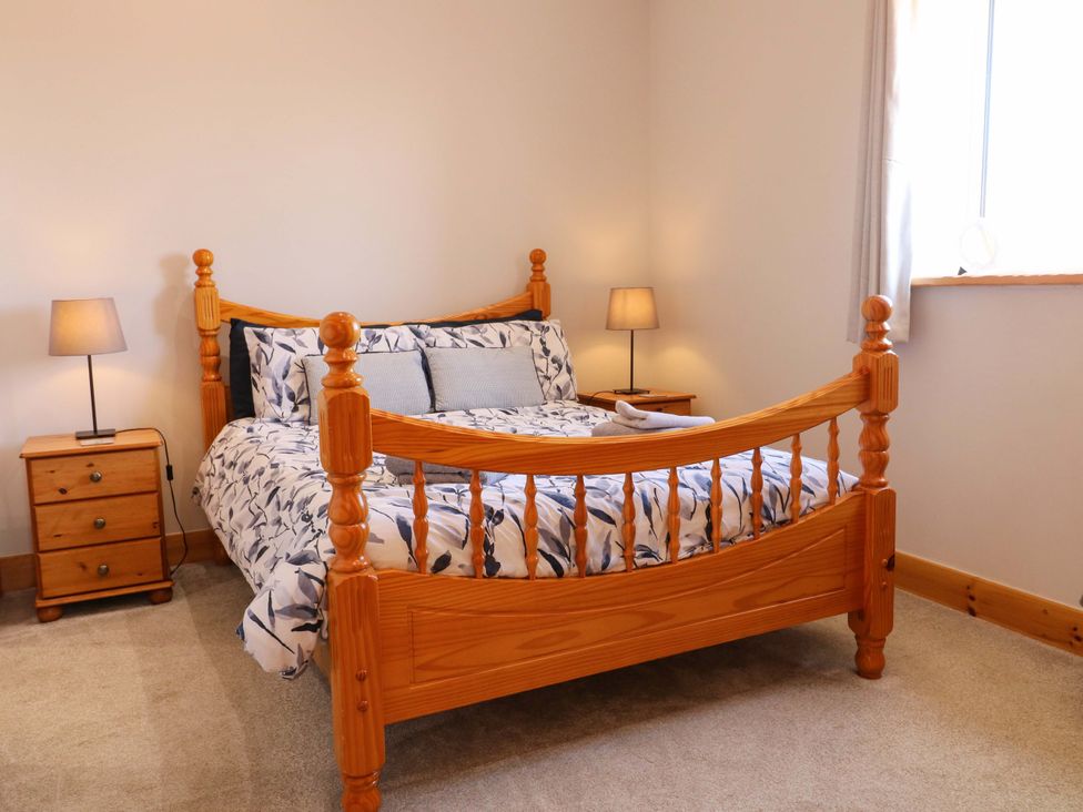 A bedroom with a bed and nightstand at Teal Cottage Melton Mowbray